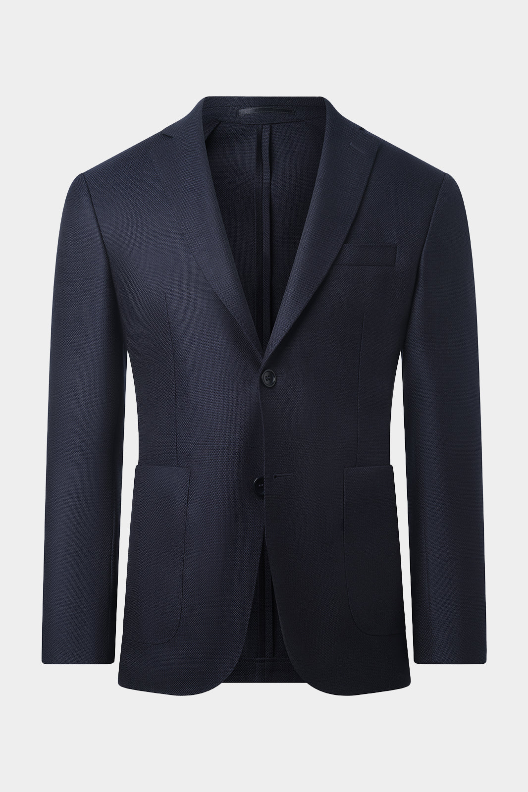 Photo de notre blazer sur un tissu italien natté en 100% laine de chez Ermenegildo Zegna. Vous apprécierez sa coupe cintrée, son montage napolitain (non-doublée et non-épaulée) avec les poches plaquées sur le devant.