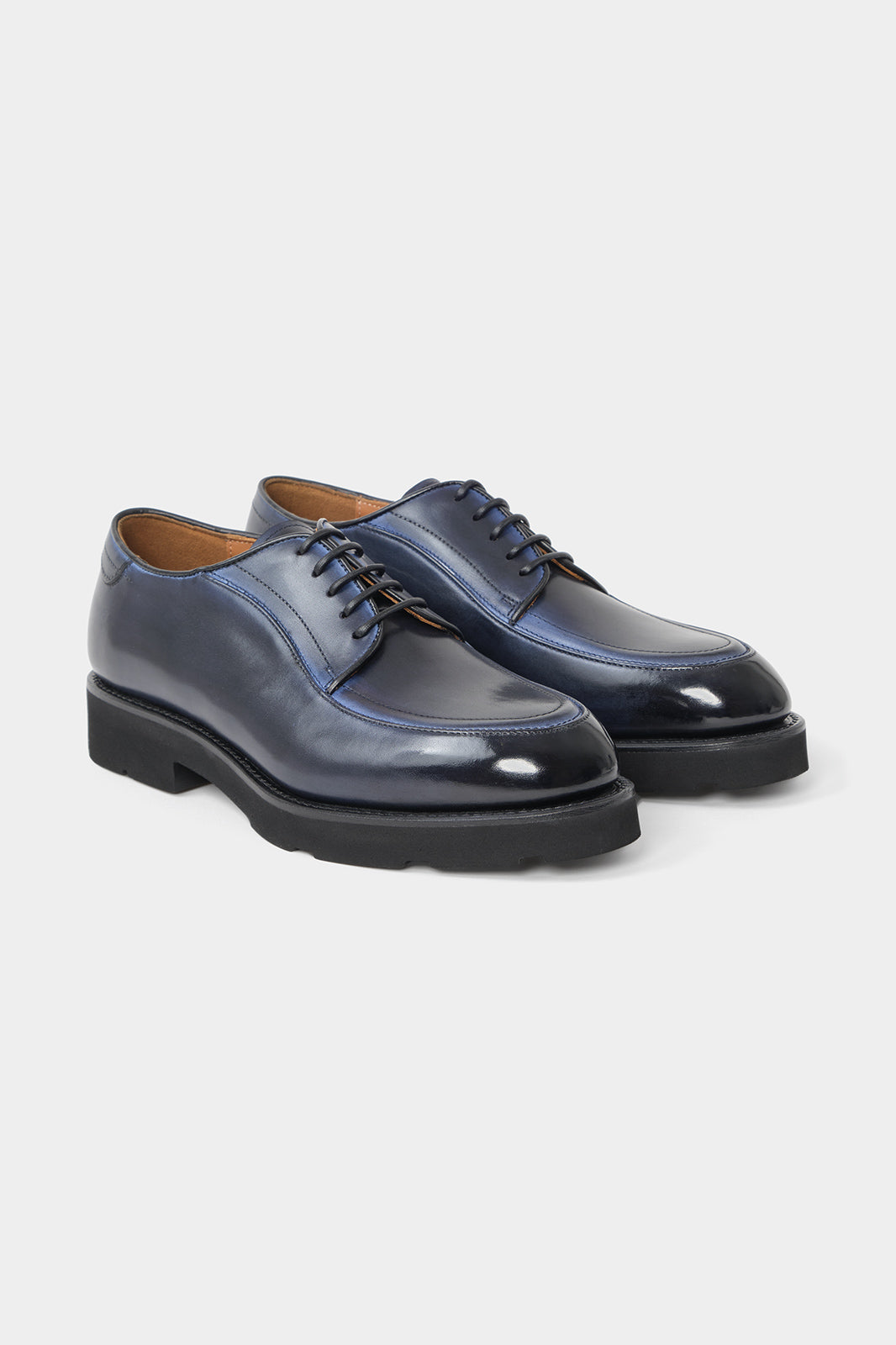Vue sur fond blanc de souliers à lacets patiné bleu. Sur une patine artisanale made in Italy.