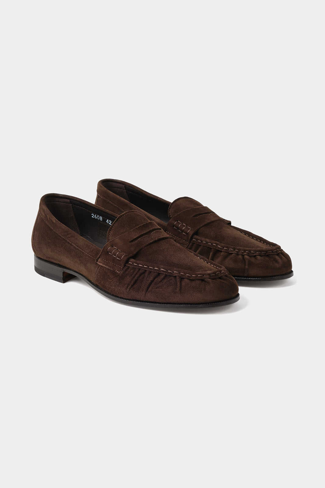 Vue sur fond blanc d'une paire de mocassins en cuir suédé marron