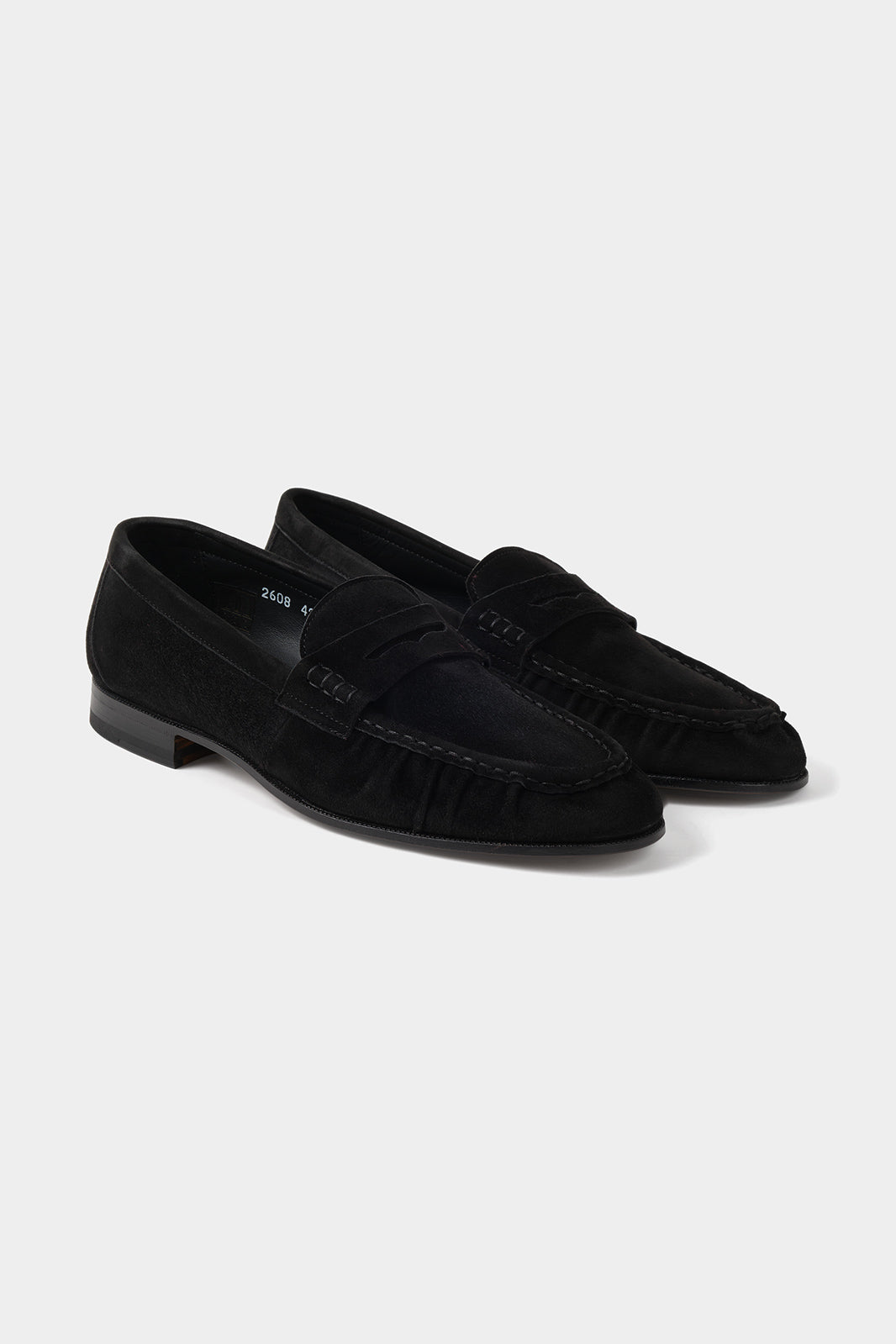 Vue sur fond blanc d'une paire de mocassins en cuir suédé en noir 