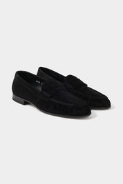Vue sur fond blanc d'une paire de mocassins en cuir suédé en noir 