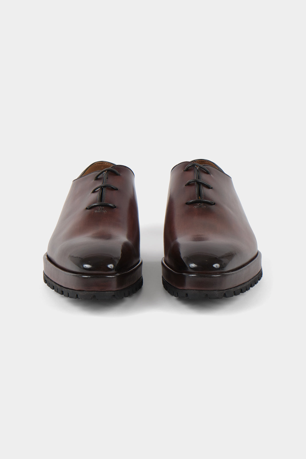 Vue sur fond blanc d'une paire de souliers à lacets patiné marron en cuir d'Italie