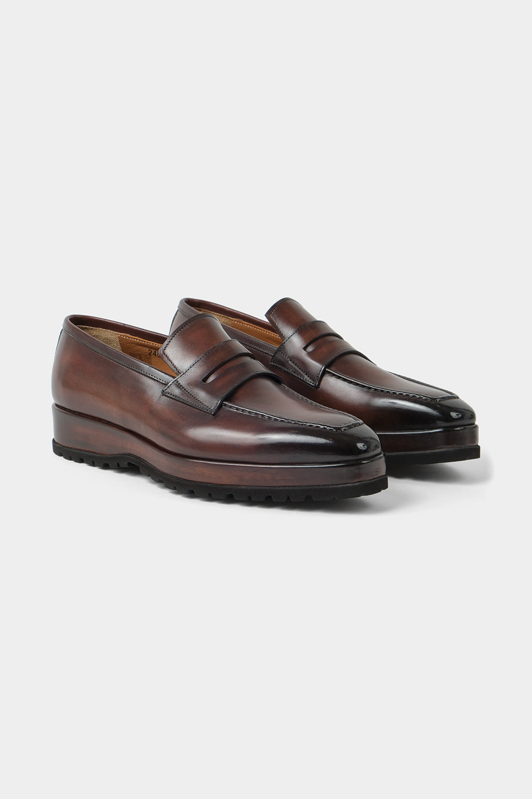 Vue sur fond blanc d'une paire de mocassins en cuir patiné avec semelle compensée et crantée couleur marron. Made in Italy en 100% cuir Almas.
