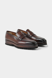 Vue sur fond blanc d'une paire de mocassins en cuir patiné avec semelle compensée et crantée couleur marron. Made in Italy en 100% cuir Almas.