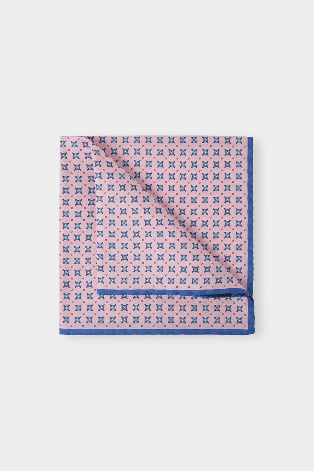 Vue sur fond d'une pochette rose à fleurs marine en 100% soie fabriqué en Italie.