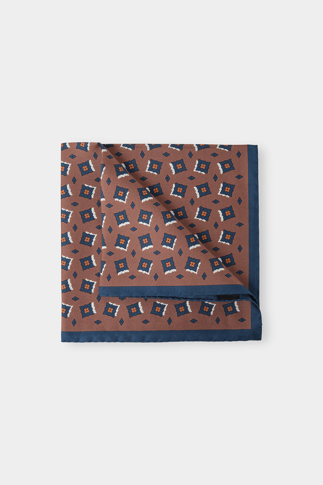 Vue sur fond d'une pochette marron à fleurs marine en 100% soie fabriqué en Italie.