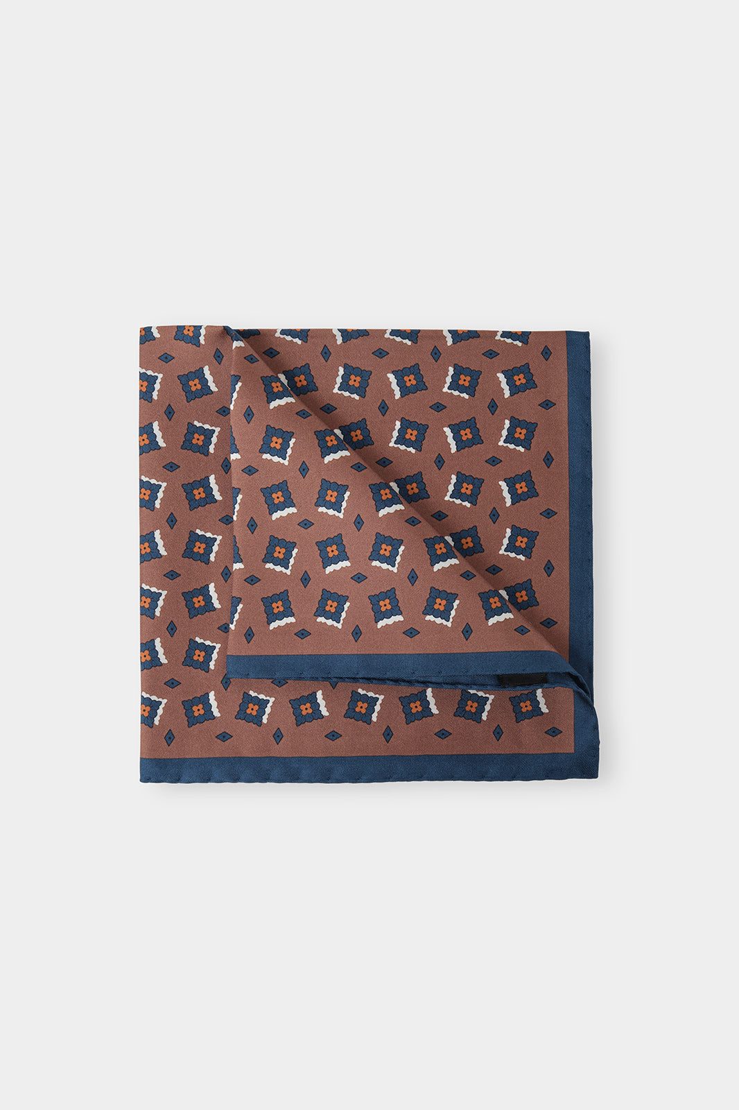 Vue sur fond d'une pochette marron à fleurs marine en 100% soie fabriqué en Italie.
