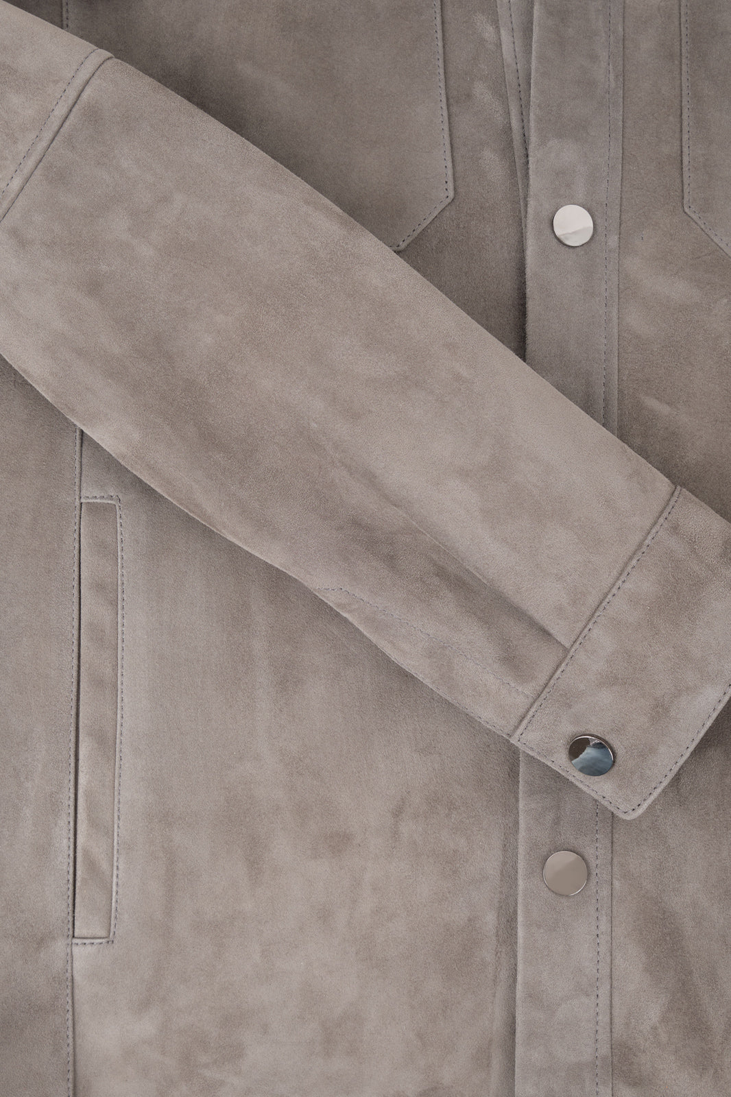 Vue d'une manche de la surchemise en peau couleur anthracite avec poche poitrine et boutonnage pression.
