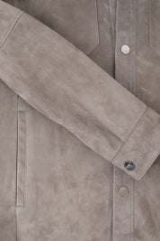 Vue d'une manche de la surchemise en peau couleur anthracite avec poche poitrine et boutonnage pression.