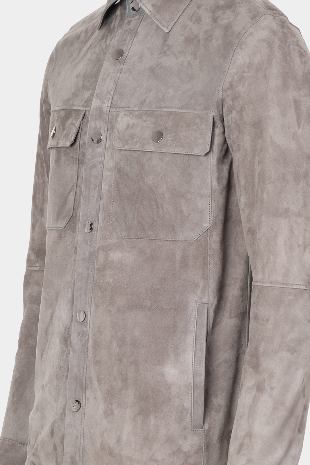 Vue de coté sur fond blanc d'une surchemise en peau couleur anthracite avec poche poitrine et boutonnage pression.