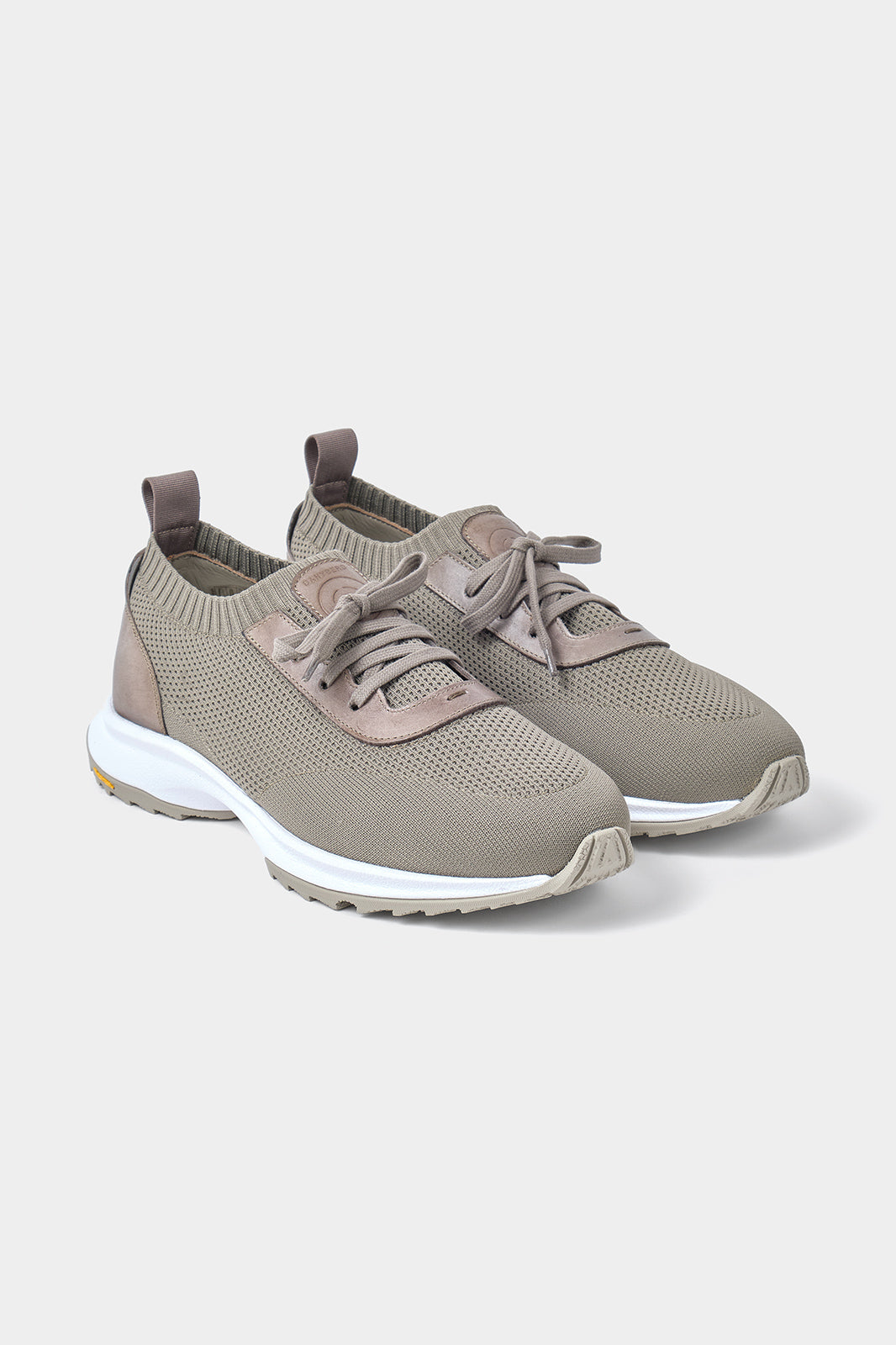 Vue sur fond blanc d'une paire de sneakers taupe avec semelle Vibram