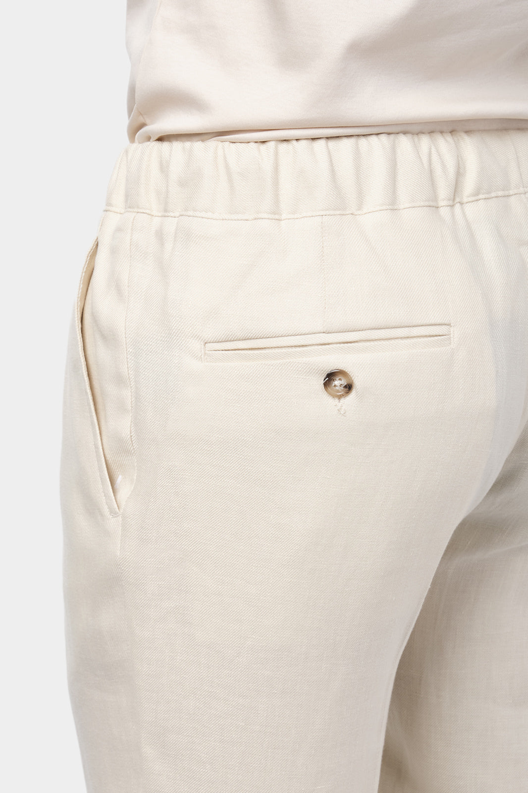 Pantalon jogpant en lin de couleur beige avec cordon de resserrage à la taille.