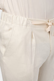 Pantalon jogpant en lin de couleur beige avec cordon de resserrage à la taille.